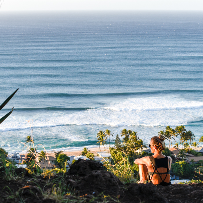 woman sitting on pillbox looking at north shore oahu
