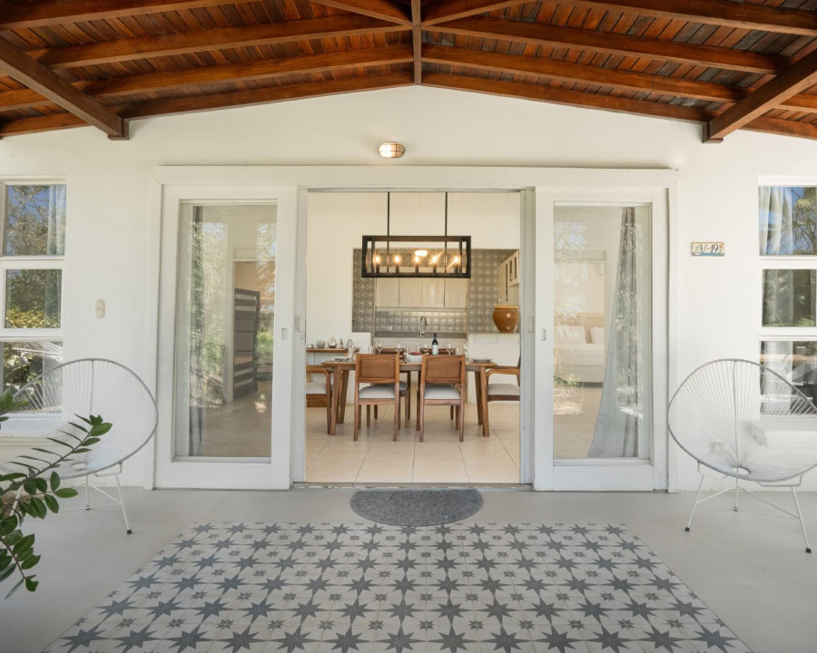 bedroom with sliding glass doors opens to a garden with small palm plants